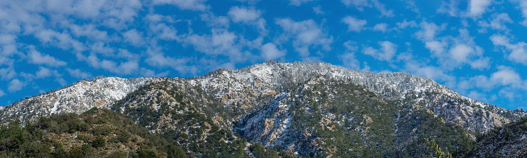 Standing in splendid isolation, the mountain's pinnacle is graced by the loneliness of its pristine snow covering.