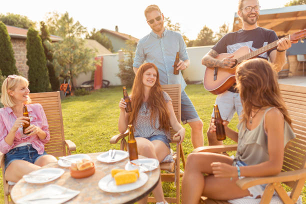 istock Friends playing the guitar and singing at backyard barbecue party 1299146737