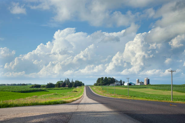 istock Rural highway in southern Minnesota with fields and a farm beneath dramatic clouds 1299146854