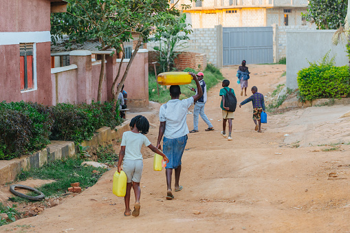 Child carrying water home from he local well in Entebbe, Uganda