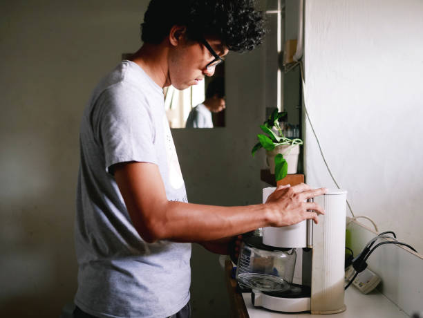 istock Young Asian man making coffee in the morning 1299147966