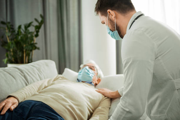 istock Medical worker checking lying patient at home 1299148111