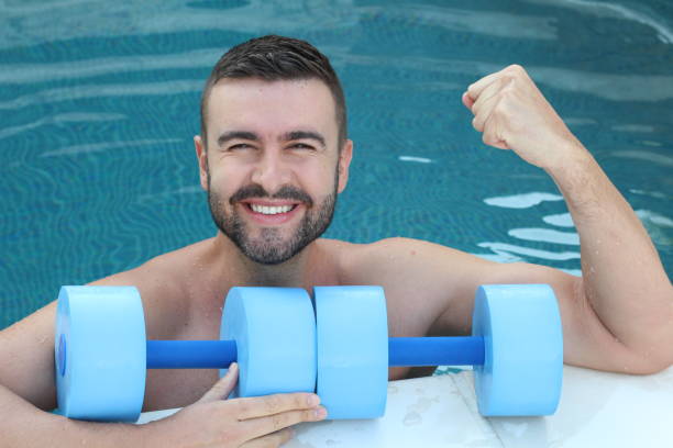 istock Young man exercising in swimming pool 1299150907