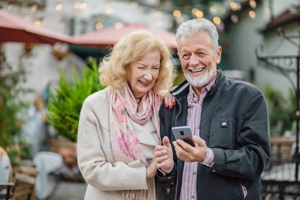 istock Lovely senior couple using mobile phone outdoors 1299152993