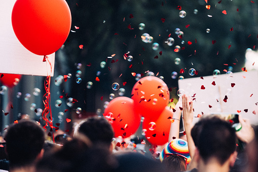 Colorful confetti, soap bubbles, and balloon on the street party, festival or lgbtqi pride walk.