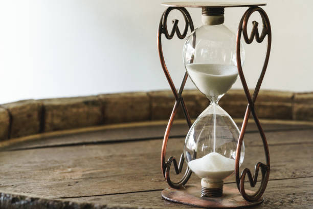 istock Sandglass on wooden bakground closeup. Time concept 1299154811