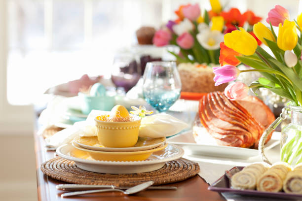 Easter Dining Table Easter ham brunch. Dining Table with a Centerpiece of Fresh Colorful Tulips carrot cake day stock pictures, royalty-free photos & images