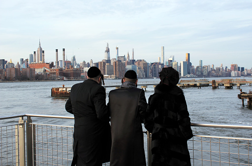 New York, America, US : 20.12.2019: Jewish family looking at lower Manhattan skyline one world trade center view  and wall street from ferry of skyscrapers buildings and offices New York, United states USA