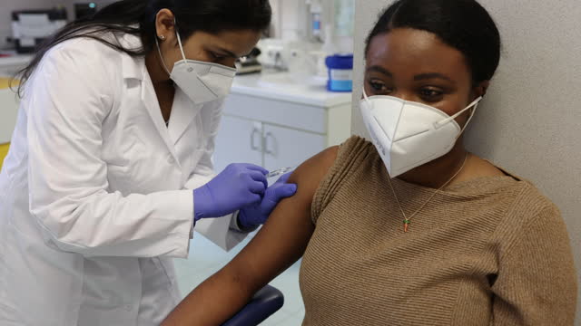 Scientist giving a vaccine to a female