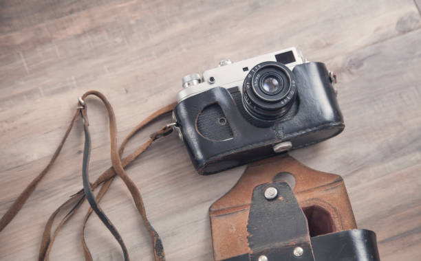 istock Old retro camera on wooden background. 1299156026