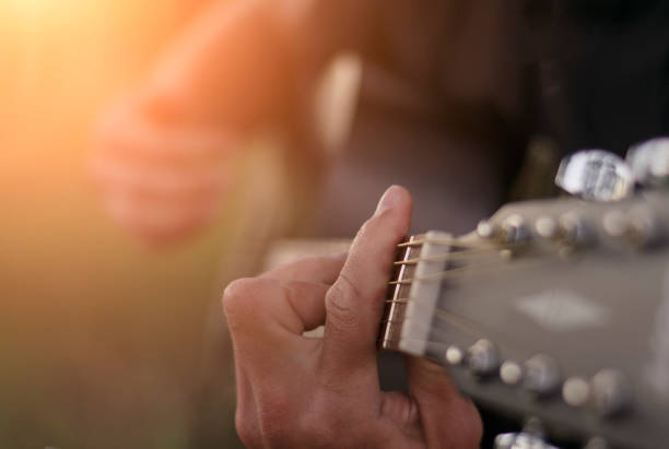 istock Hands of a man playing the guitar, close up, selective focus. 1299156097