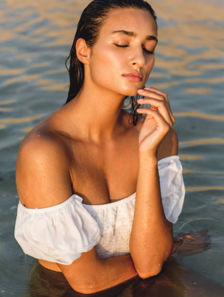 海の水の中に濡れて立ってセクシーな女性モデル。 - sensuality sex symbol women breast ストックフォトと画像