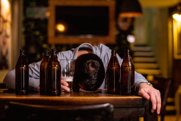 Young drunk man sleeping on bar counter stock photo