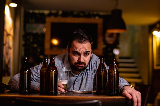 Young drunk man sleeping on bar counter