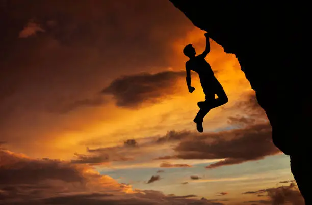 Man free climbing at sunset.