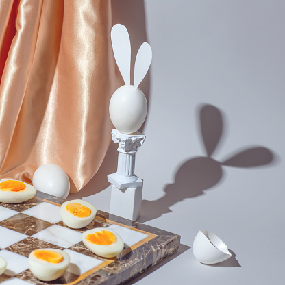 Easter chess play with fresh and boiled eggs, still life concept