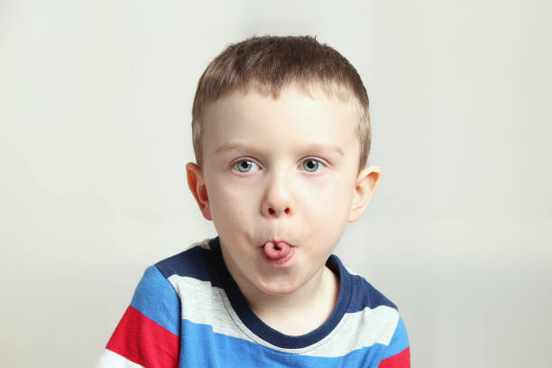 istock Boy, kid performs articulation exercises for the tongue, correct pronunciation, vocals, dental concept, speech therapy 1299161913