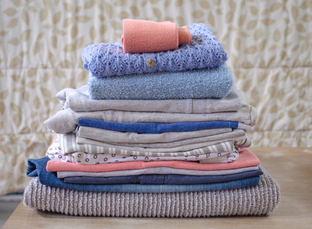 istock Stack of folded pastel colors clothes on blurred background. Clean and soft clothes pile. 1299162554