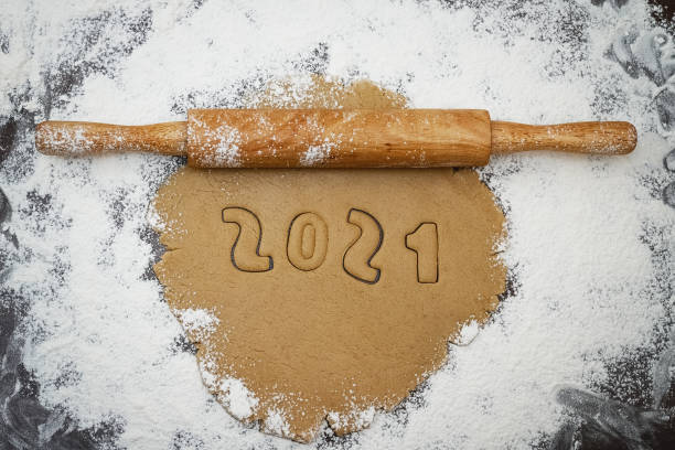 istock 2021 numbers cut from rolled raw cookie dough on flour brown table and rolling pin 1299163205