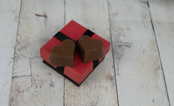 istock small red and black gift box and some heart-shaped chocolates. valentine concept 1299163369
