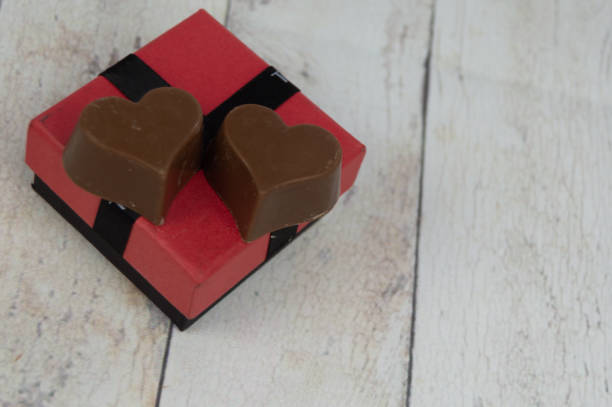 istock small red and black gift box and some heart-shaped chocolates. valentine concept 1299163965