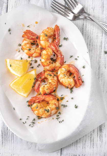 istock Shrimps with thyme and lemon wedges 1299166648