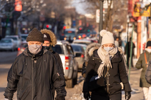 пешеходы в масках для защиты от covid-19 идут по улице - city street montreal street city стоковые фото и изображения