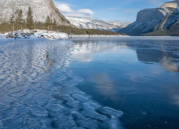 Reflections in frozen Lake Minnewanka in Banff National Park, Alberta, Canada