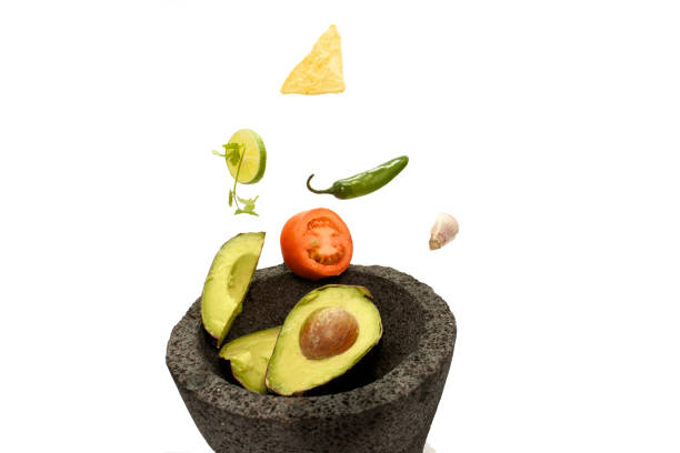 A close up of some guacamole and a red jalapeno corn chip in a small plastic molcajete bowl.