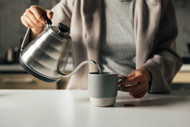 rituali mattutini: una donna anonima che intrisa di tisane - steep foto e immagini stock