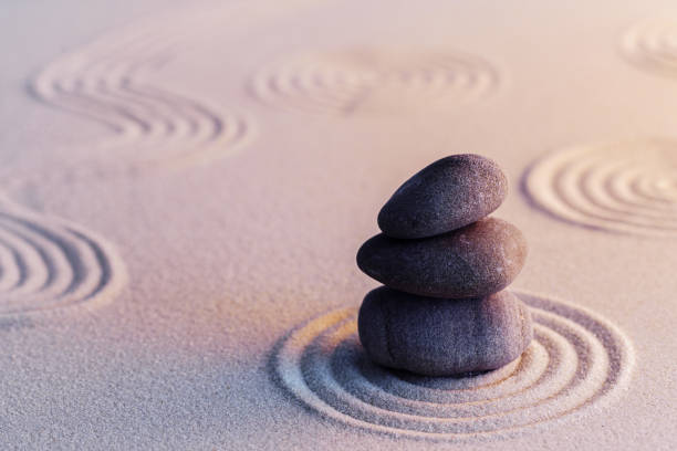 istock Meditation zen garden with stones on sand 1299171400