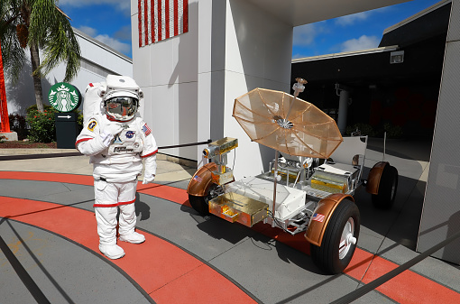Merritt Island, Florida, USA - October 26, 2020:  Kennedy Space Center's Astronaut stands by the Lunar Roving Vehicle at the visitors complex.