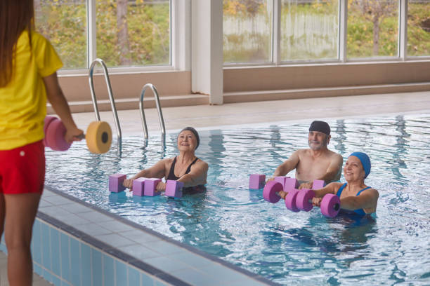 istock Coach instructing water aerobics class for group of seniors 1299173580