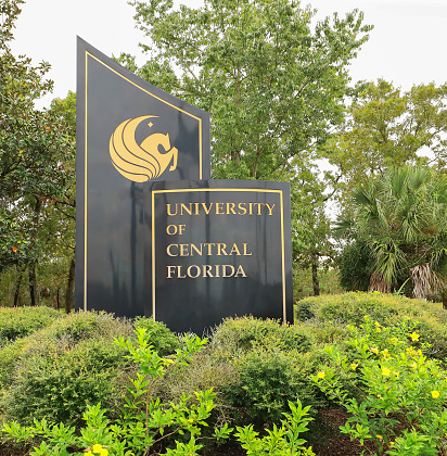 Orlando, Florida, USA - October 24, 2020:  University of Central Florida's main entrance sign at the corner of North Alafaya Trail and University Boulevard on UCF's main campus.
