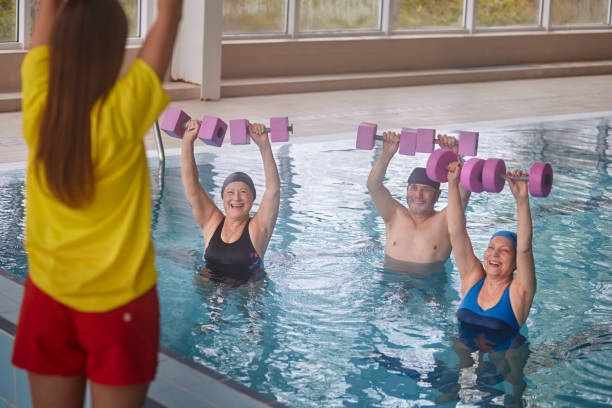 istock Group of seniors in aerobics class raising dumbbells with instructor 1299174561