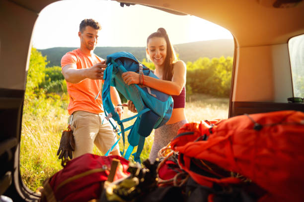 istock Young couple  unloading the car trunk and getting ready for adventure 1299175726