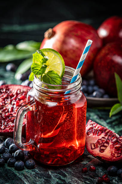 istock Pomegranate and Blueberry Juice with Straw on Marble Green Background 1299177377