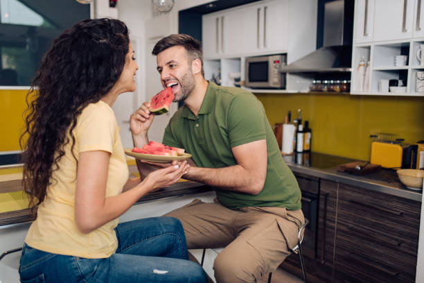 istock Happy couple eating watermelon and enjoying together 1299180706