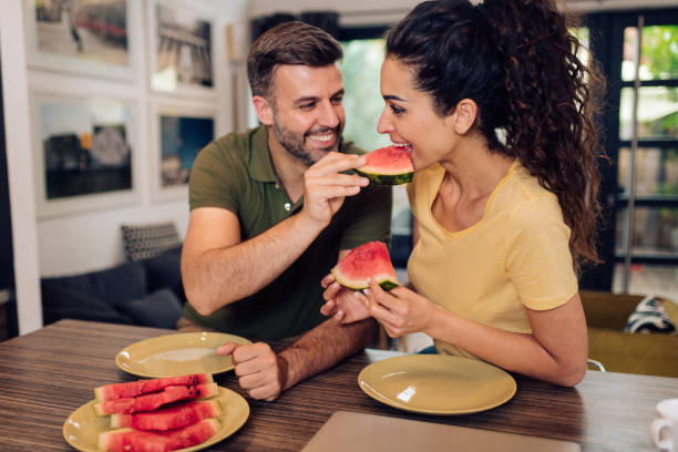 istock Happy couple sharing sweet watermelon 1299180709