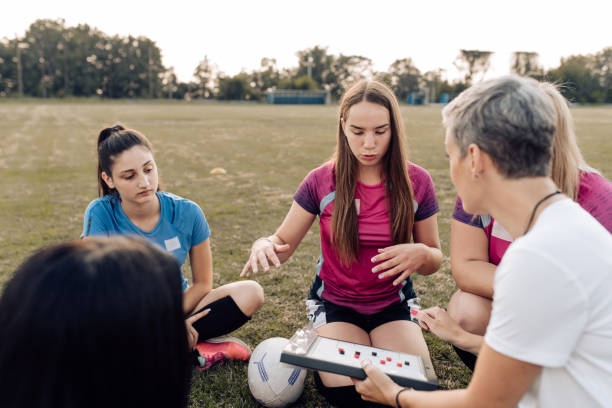 istock Female rugby coach making a play tactic with her team 1299180761
