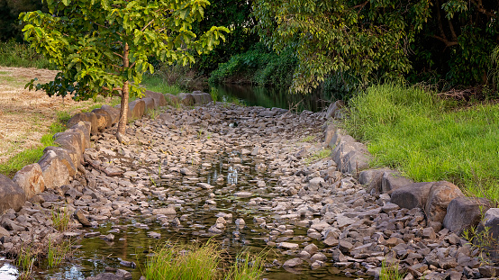 Stones along a constructed drain emptying into a creek