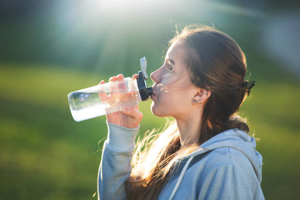 istock Sporty woman drinking water after exercise 1299182688