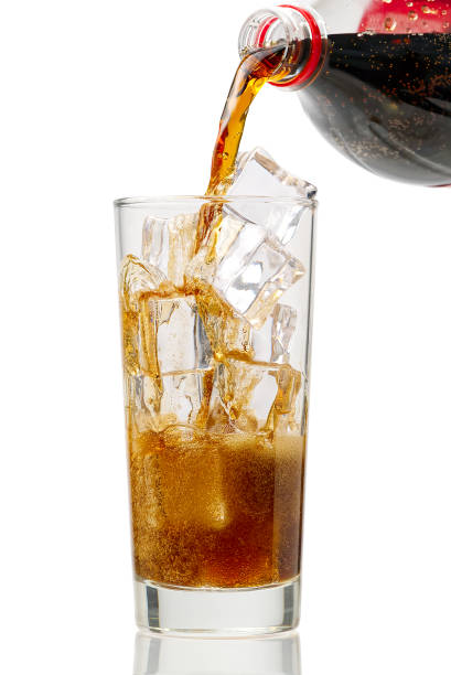 istock Pouring Cola to glass with ice cubes isolated on white 1299183444
