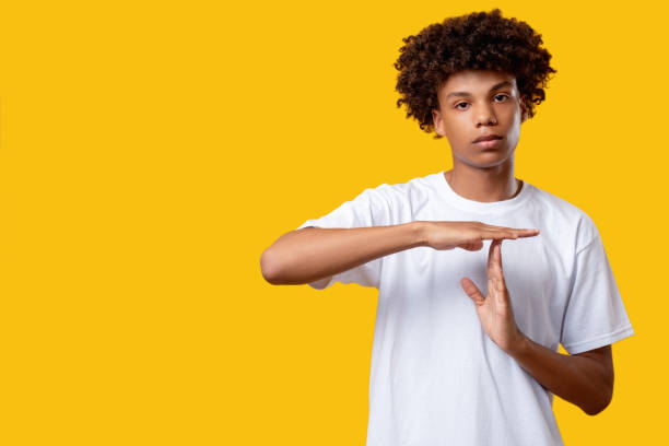 time out gesture need break tired black teenager Time out gesture. Need break. Tired black teenager boy showing stop by hands looking at camera isolated on orange copy space. No racism. Pause message time out signal stock pictures, royalty-free photos & images