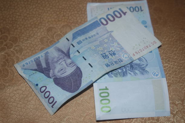 istock Korean won notes scattered over a wooden floor 1299185494