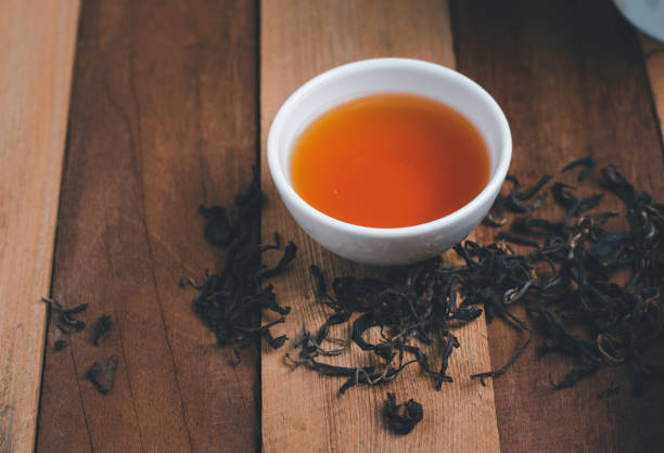istock A tea cup with dry tea and wooden background 1299186336