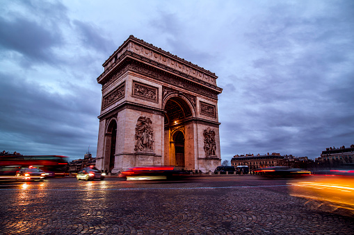 Long exposure shot of Arc De Triomphe in Paris, France with cars passing by