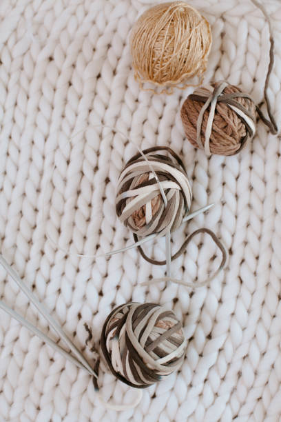istock Yarn balls on white background with knitting needles. Knitting blanket concept, 1299193403