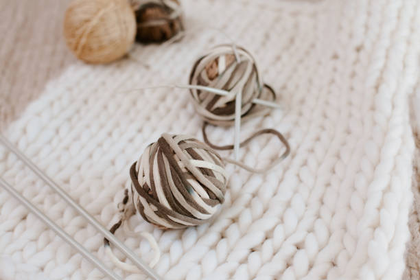 istock Yarn balls on white background with knitting needles. Knitting blanket concept, 1299193412