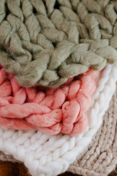 istock Four thick knitted handmade blankets layered on each other. Green, pink, white and beige handknitted blankets, 1299193479